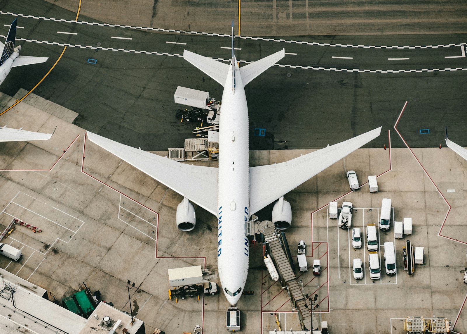 Aerial view of a wide-body aircraft being loaded on the apron